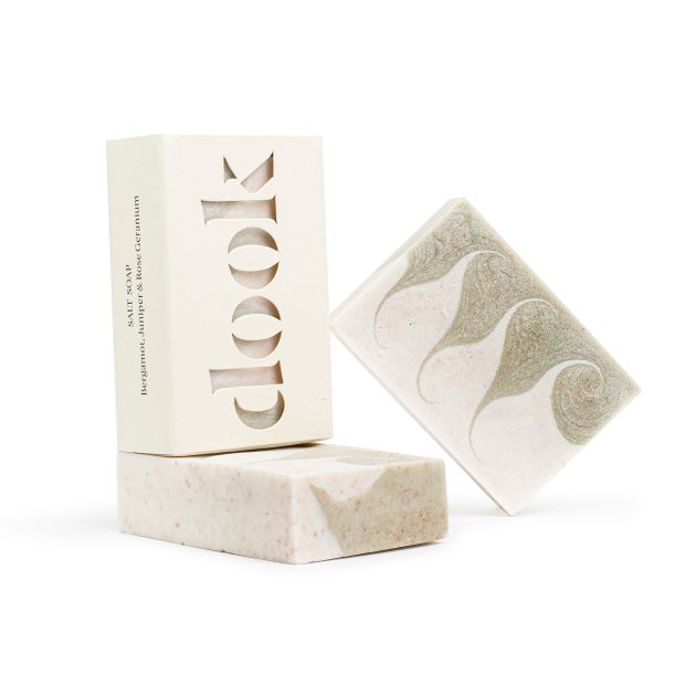 Three bar of soap, one boxed and two unboxed with green pattern of swirls across the horizontal side of the bar.