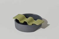Porcelain soap dish in two pieces put together - dark grey base and moss green wavy top.