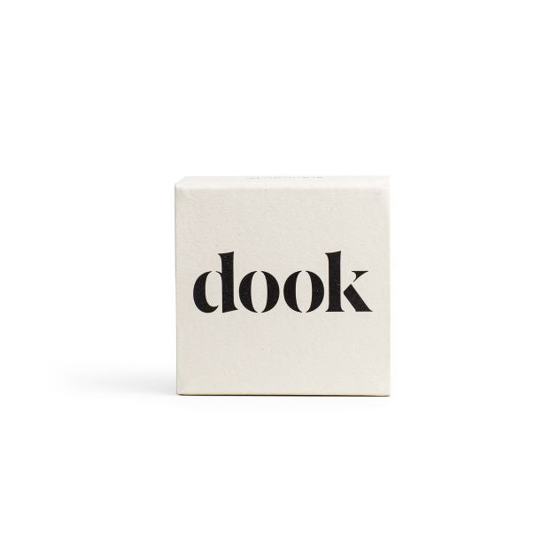 Shampoo bar in a white square packaging with black dook logo on the front.