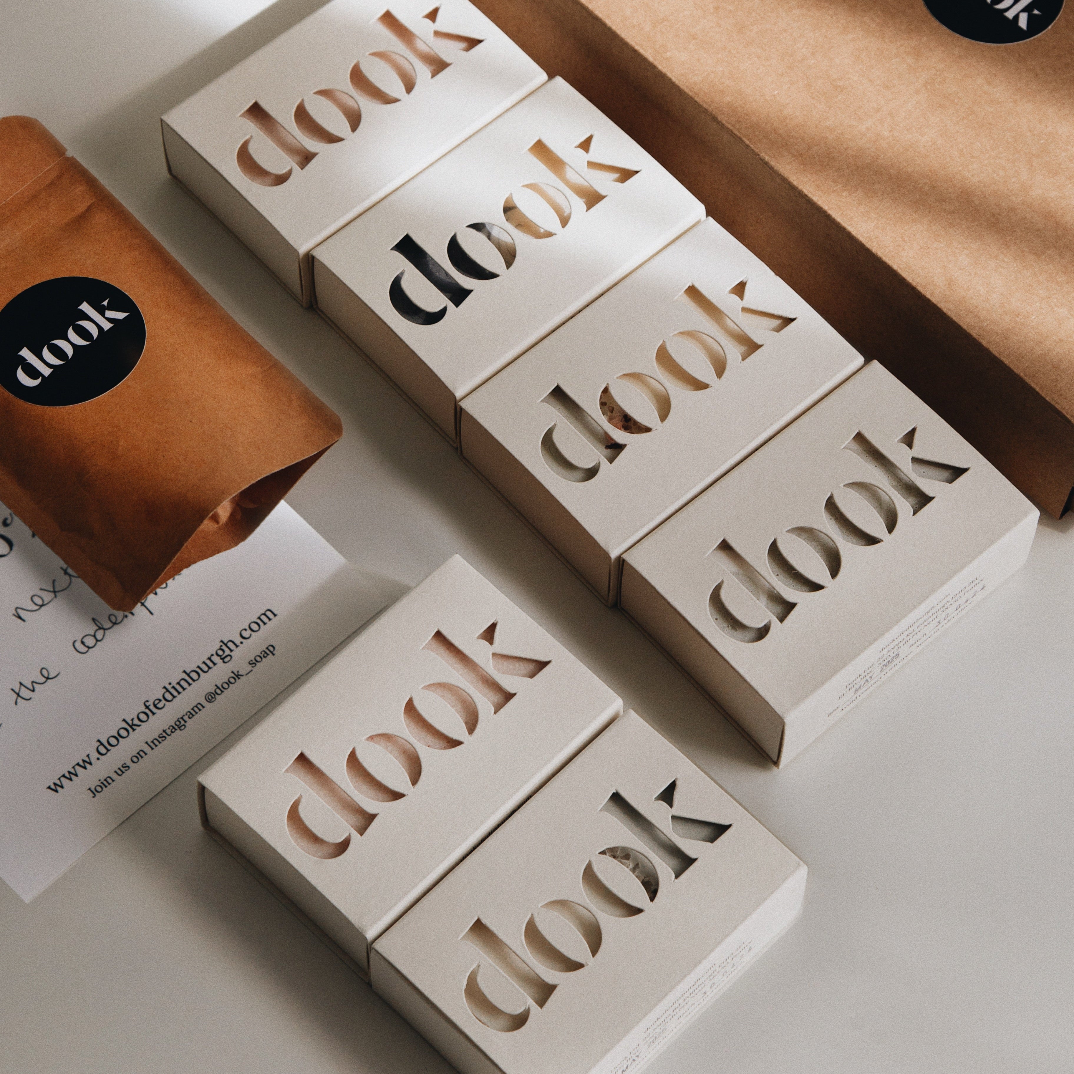 Subscription box offer image of six boxed bar of soaps layered flat next to a brown box along with the sample bag and a card..