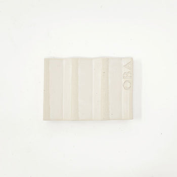 White zig-zag shaped OBA Ceramic soap dish on the white background - underneath view.