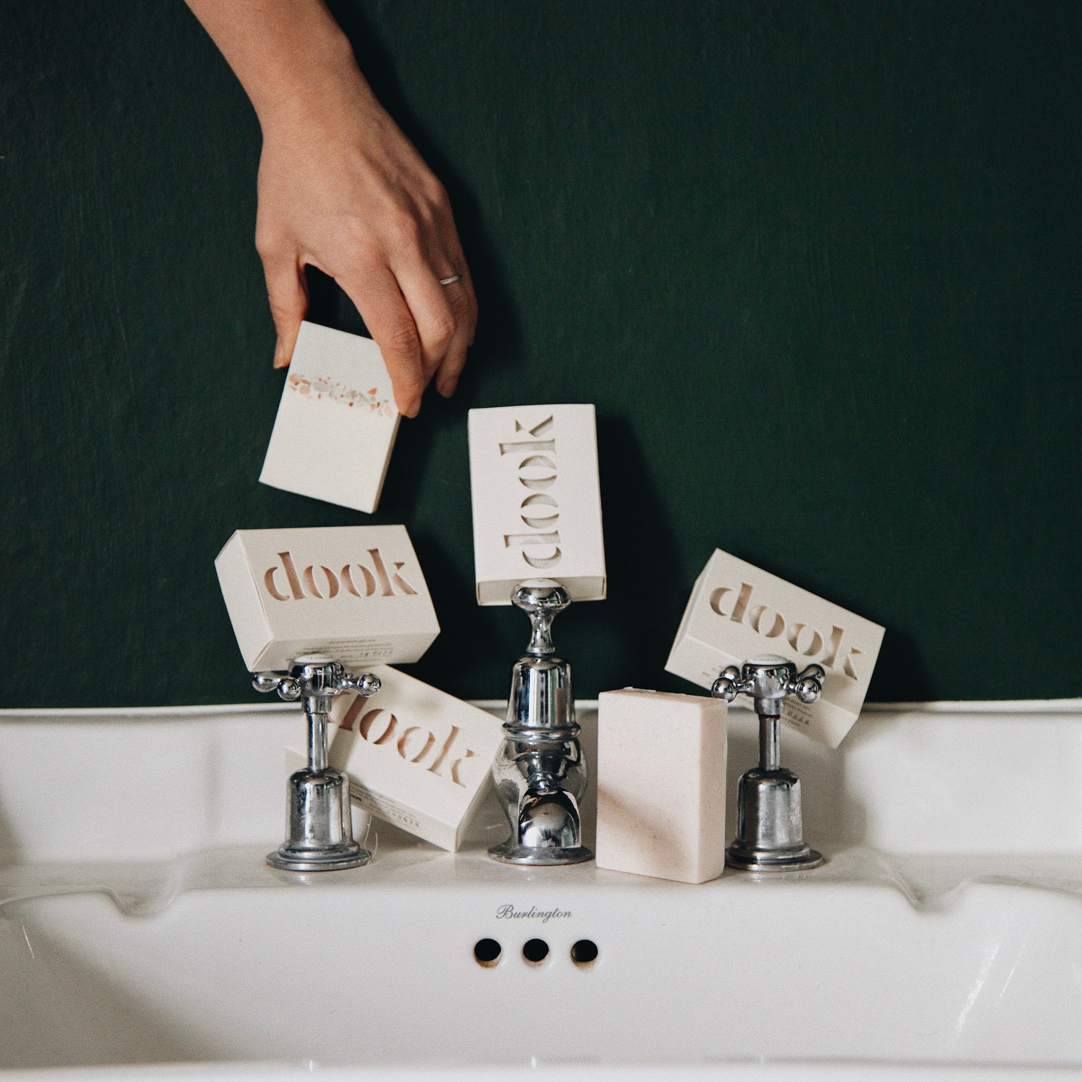 Hands holding lathered rosemary and frankincense wet bar of soap in the background of the rest of the body.