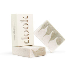 Three bar of soap, one boxed and two unboxed with green pattern of swirls across the horizontal side of the bar.