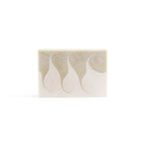 A creamy-white handmade bar soap with a light green wavy swirls across, on the white background.