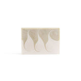 A creamy-white handmade bar soap with a light green wavy swirls across, on the white background.