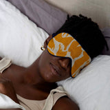 Model relaxing with a yellow linen and merino eye mask