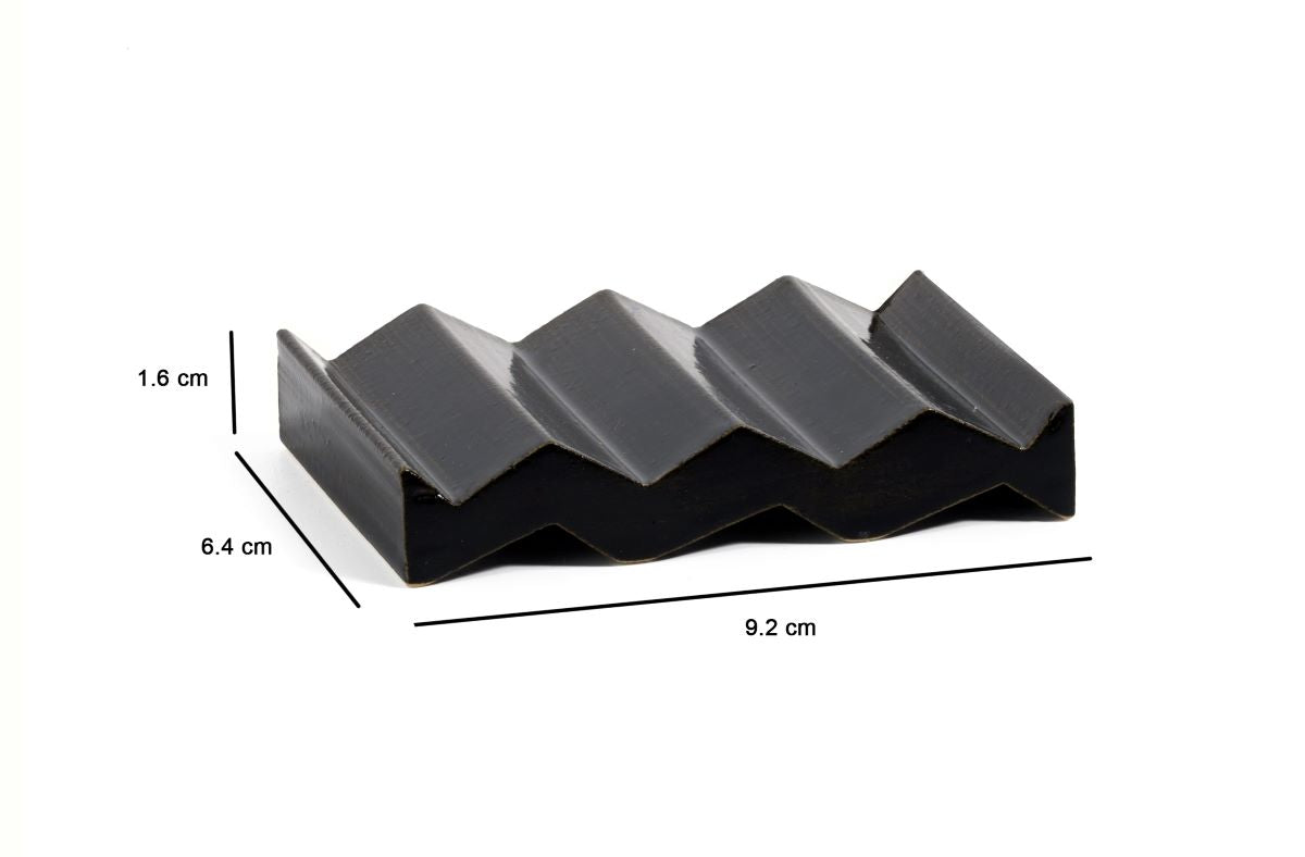Black zig-zag shaped OBA Ceramic soap dish on the white background with dimensions: 1.6 cm x 6.4 cm x 9.2 cm.