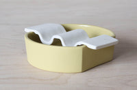 Porcelain soap dish in two pieces put together - citron yellow base and white wavy top.
