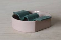 Porcelain soap dish in two pieces put together - dusty pink base and forest green wavy top.