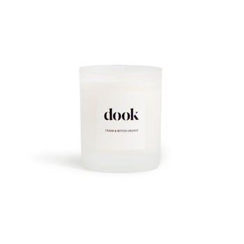 Candle in a glass jar with dook logo label on the white background.