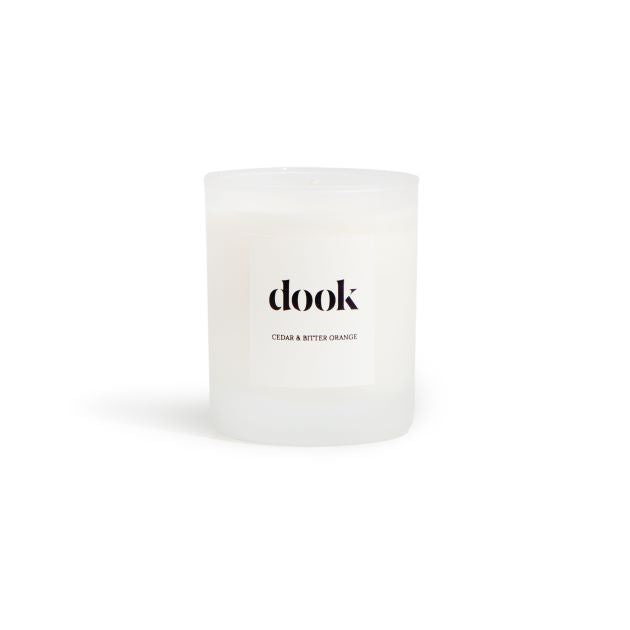 Candle in a glass jar with dook logo label on the white background.