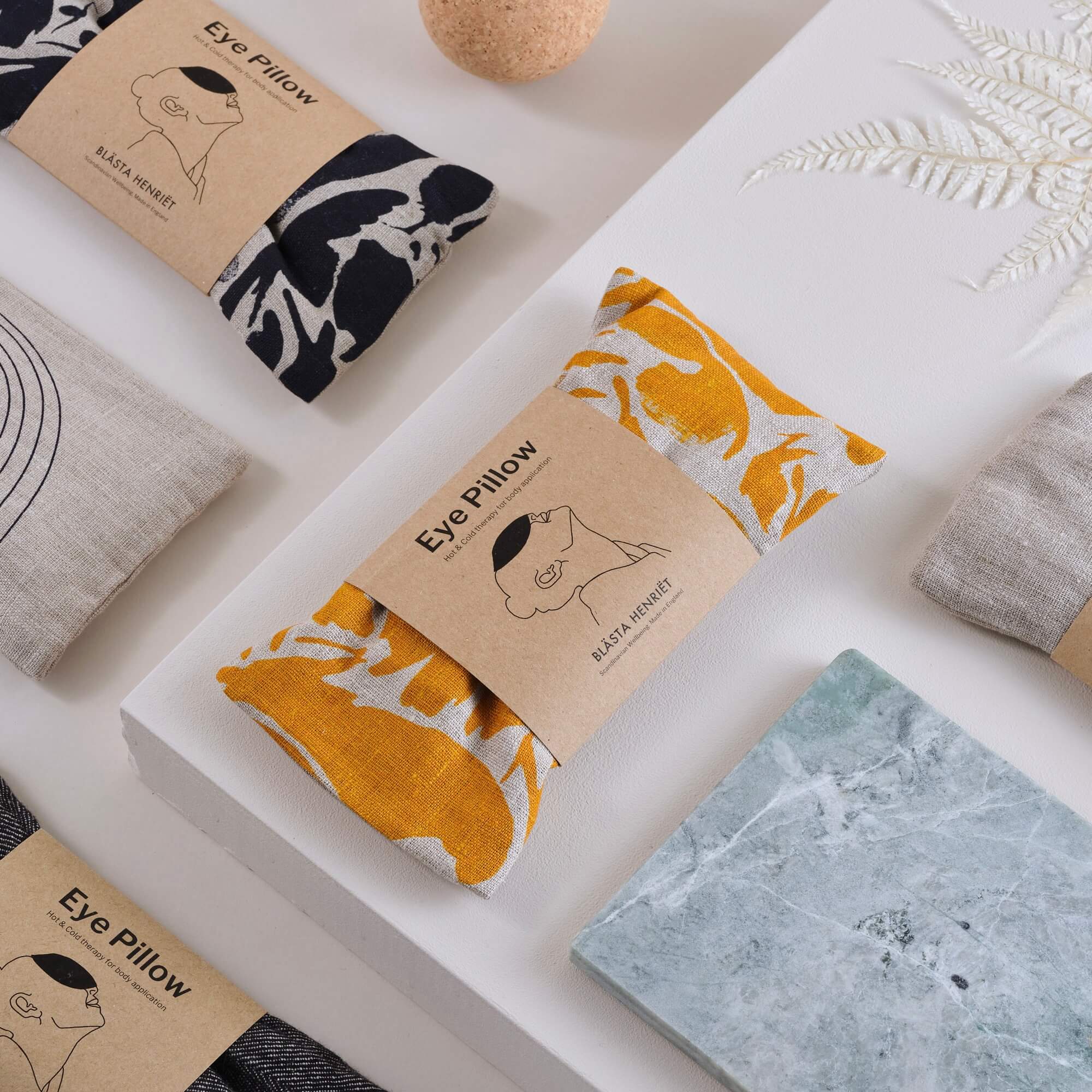 An arrangement of two colour variants eye pillows and other decorative elements.