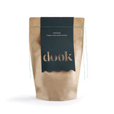 Brown paper bag of bath salts with a green label on the white background.
