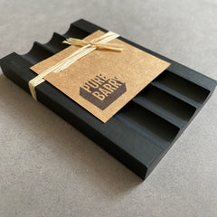 Black soap dish 'Pure Barry' with paper label.