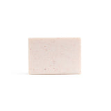 A bare, light pink handmade bar of soap on the white background.