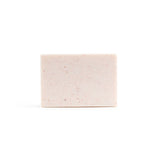 A bare, light pink handmade bar of soap on the white background.