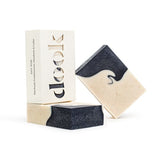Three bars of handmade soap with black swirly pattern. Two soaps are unboxed and one is in a recycled paper box with the dook logo. 