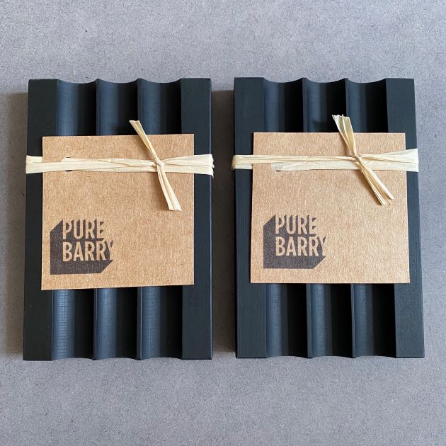 Two black 'Pure Barry' soap dishes next to one another.