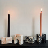 Four candle holders on a display shelf. Two candle holders with matching lit candles.