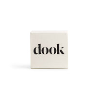 Shampoo bar in a white square packaging with black dook logo on the front. 