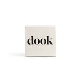 Shampoo bar in a white square packaging with black dook logo on the front. 