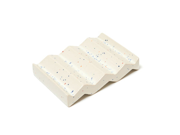 Speckled white zig-zag shaped OBA Ceramic soap dish on the white background top view.