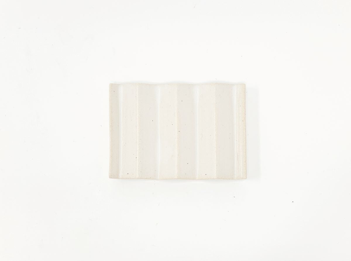 White zig-zag shaped OBA Ceramic soap dish on the white background top view.