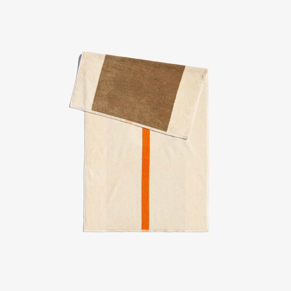 Folded bath towel with a solid orange stripe on one side and a chestnut brown block on the other, with a small white loop at the bottom.