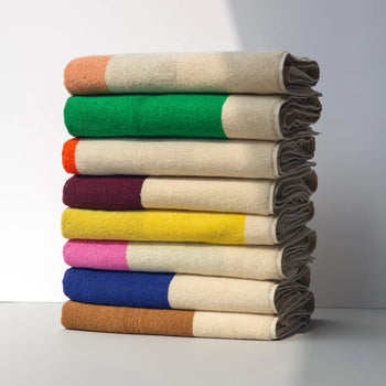 Stack of folded blankets with colorful stripes on a white background