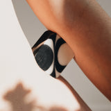 Close-up of a person's arm and hip with a black and white soap bar